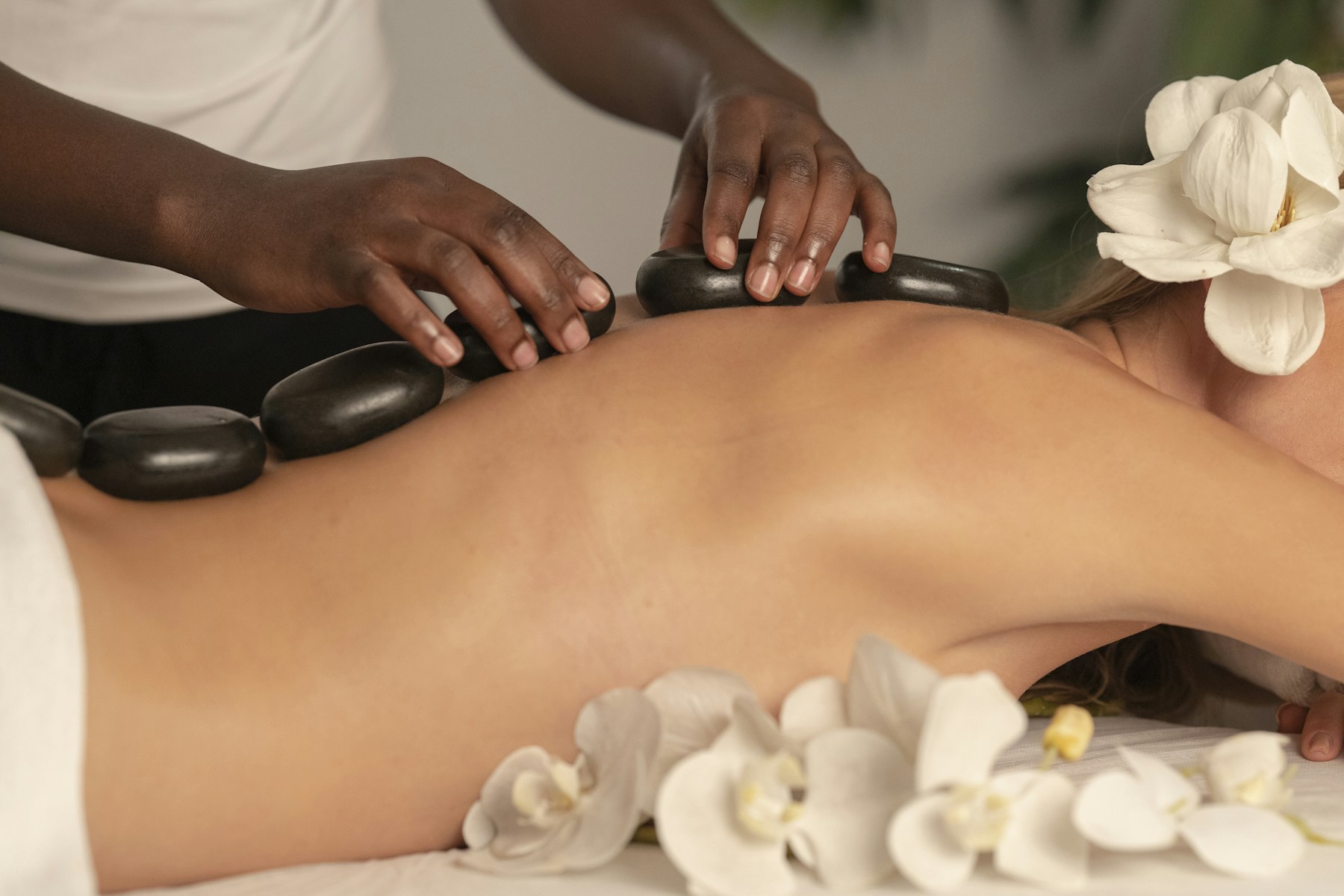 Massage de détente aux pierres chaudes avec fleurs claires
