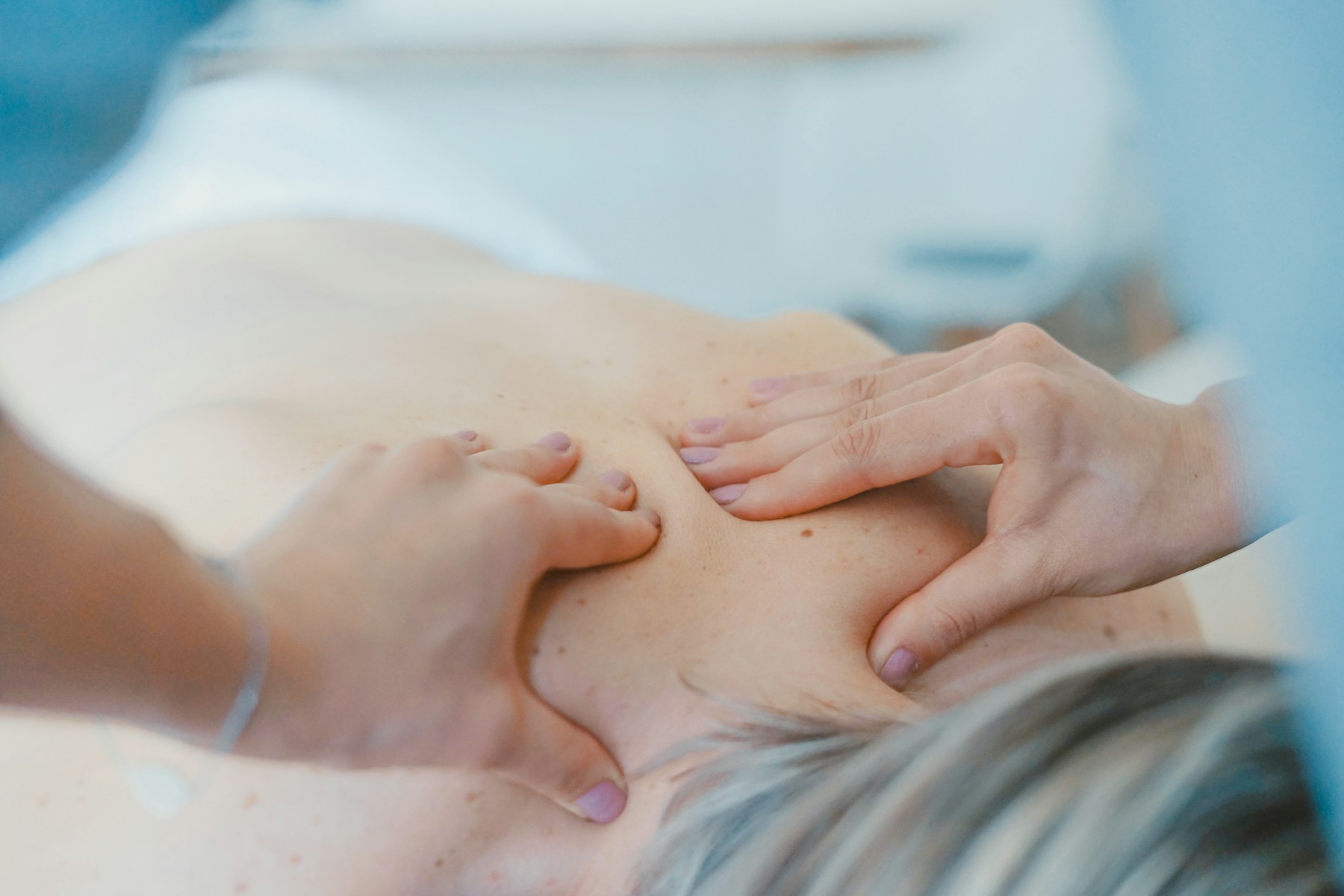 Mains de masseuse effectuant une pression lente lors d'un massage de détente